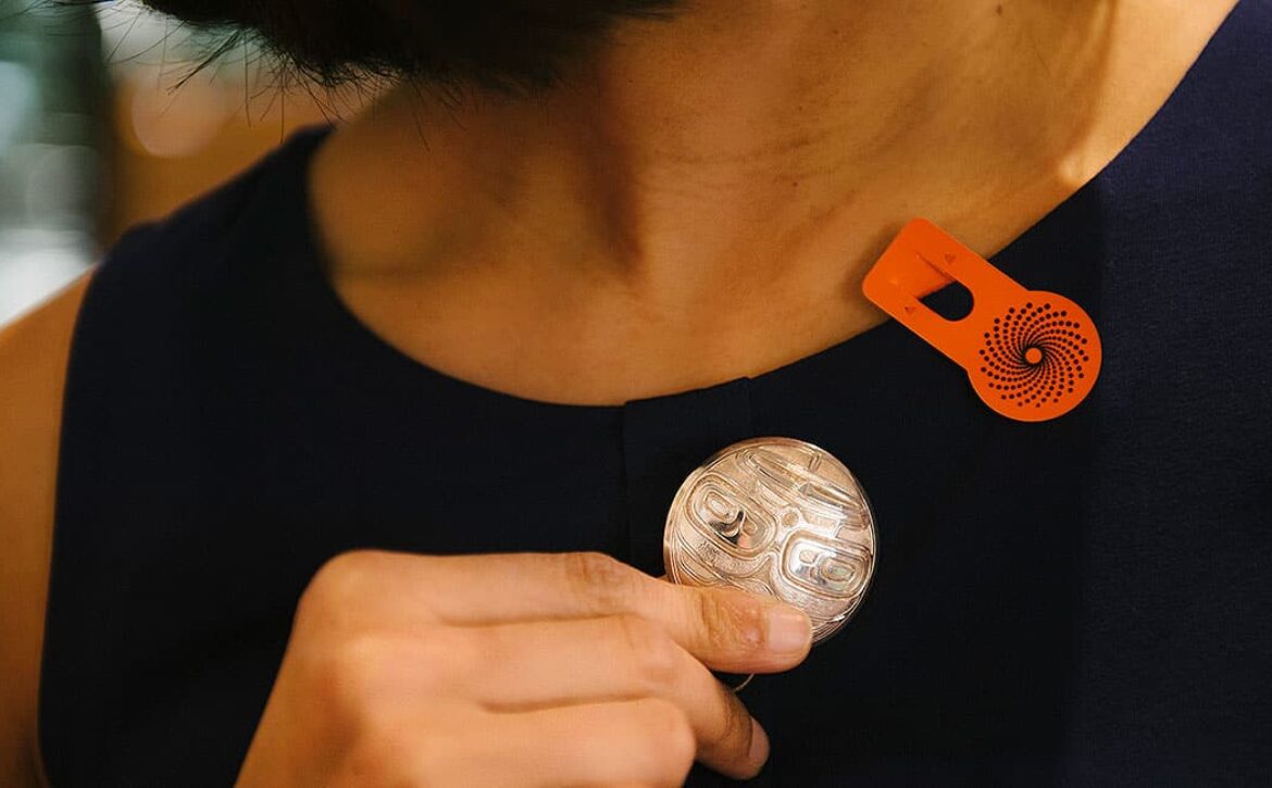 close-cropped photo of woman wearing silver broach