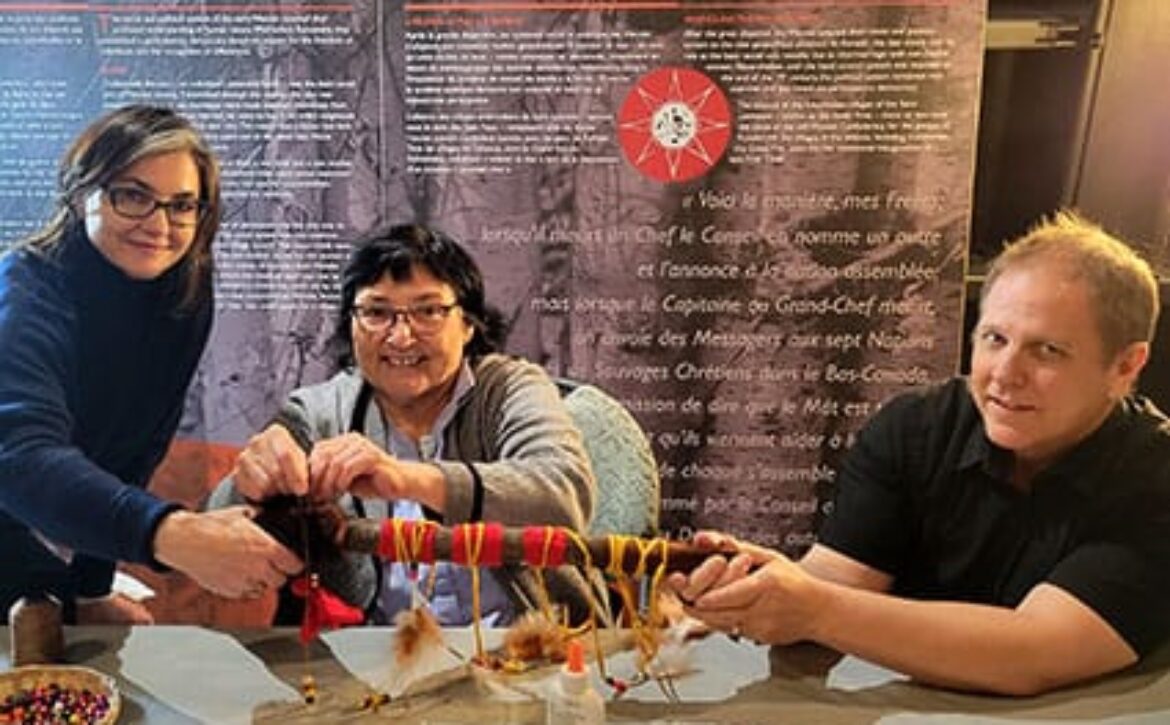 photo of two women and a man making a talking stick