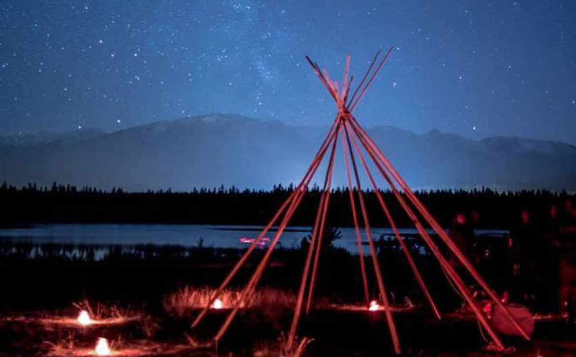 photo of teepee frame in the night sky