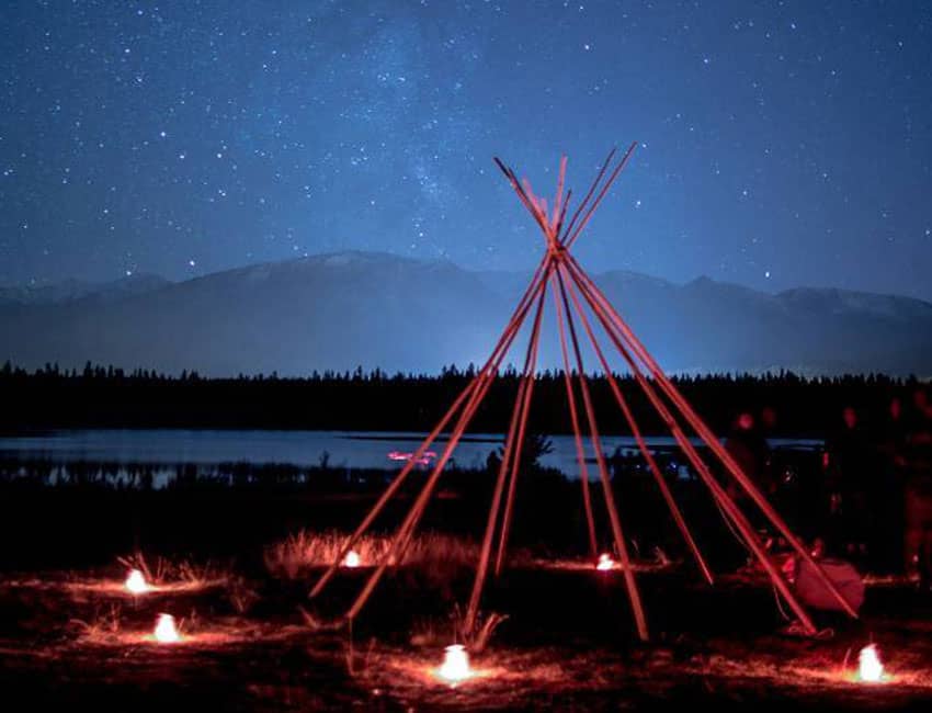 photo of teepee frame in the night sky