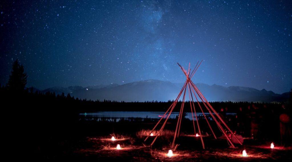 photo of teepee frame in the night sky